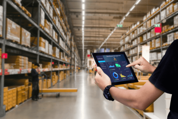  A worker using an ipad with warehouse management software inside of a facility
